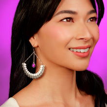 Load image into Gallery viewer, Close-up of a woman wearing a silver earring with a purple gemstone against a pink background