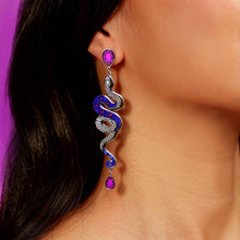 Load image into Gallery viewer, Serpentine earring with purple gemstones worn by a person against a purple background