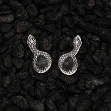 Load image into Gallery viewer, Silver snake-shaped earrings on a dark stone surface