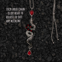 Load image into Gallery viewer, Necklace with snake design and red beads on a dark textured background