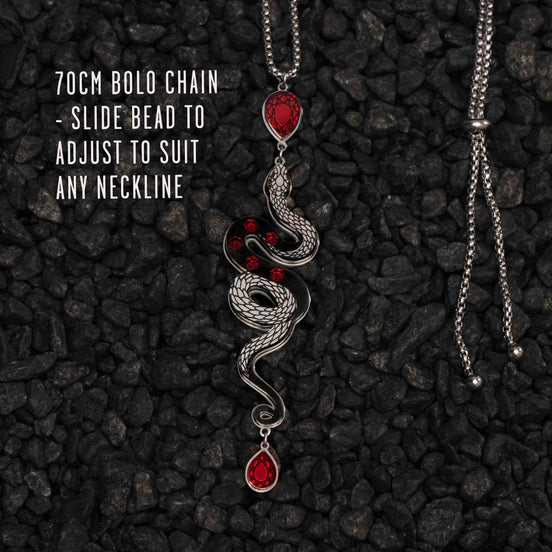 Necklace with snake design and red beads on a dark textured background