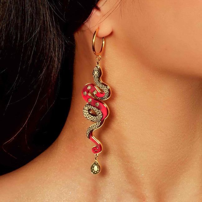 red and gold year of the snake gold hoop earrings on models ear