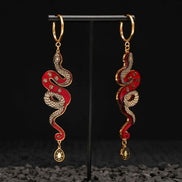 red and gold year of the snake gold hoop earrings on black background 