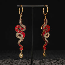 Load image into Gallery viewer, red and gold year of the snake gold hoop earrings on black background 