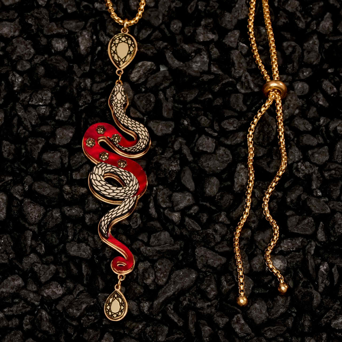 Snake-shaped pendant necklace on a dark textured background