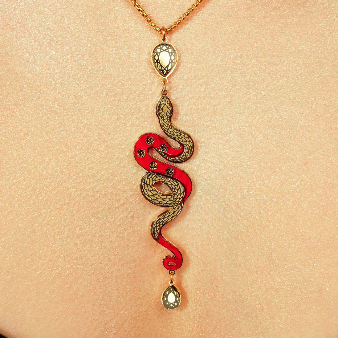 Snake-shaped pendant necklace on a person's neck against a beige background