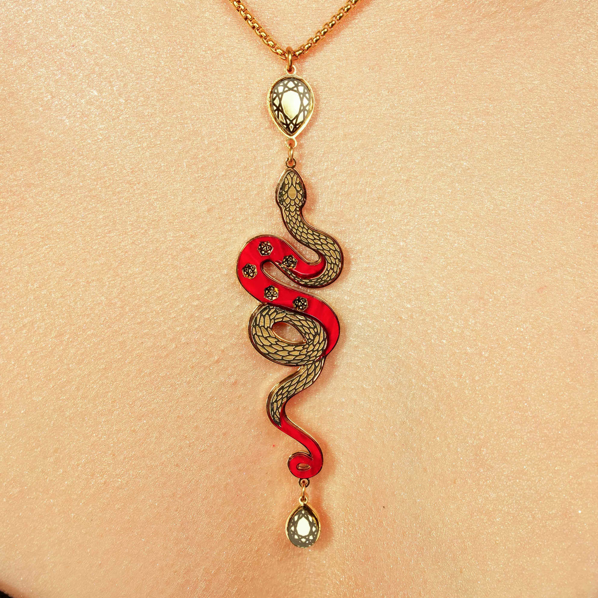 Snake-shaped pendant necklace on a person's neck against a beige background