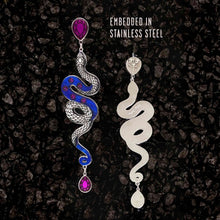 Load image into Gallery viewer, Snake-shaped earrings with embedded stones on a dark textured background
