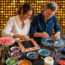 Load image into Gallery viewer, A man and a woman sit at a table making colorful mosaic art. The woman wears a white blouse and the man wears a dark blue button-up shirt.
