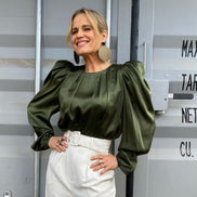 Shaynna Blaze in olive green satin blouse wearing Maine and Mara gold oversized statement earrings