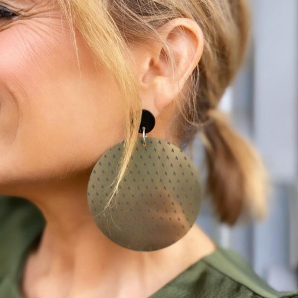 Close up of Shaynna Blaze in olive green satin blouse wearing Maine and Mara gold oversized statement earrings
