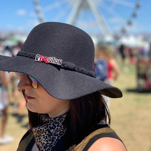 Person wearing unique LOVE REVOLUTION Statement Brooch on hat handmade by Maine and Mara