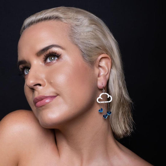Person wearing Maine and Mara Clip-on Earrings with Love Rain Cloud and blue heart Dangles