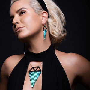 Person wearing Australian-made Maine and Mara Pride teal CHIMETTES Statement Earrings and necklace