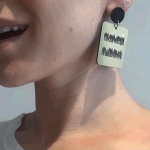 Person wearing handmade Maine and Mara EQUALITY DANGLES Statement Earrings in Gold