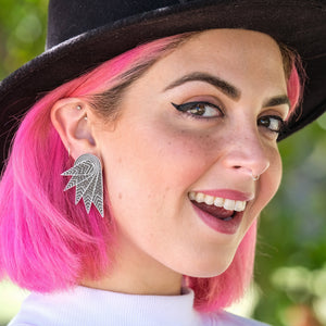 Person wearing Australian-made THE COCKIE COLLAB Wings Clip-On Statement Earrings by Maine and Mara and Mulga the Artist
