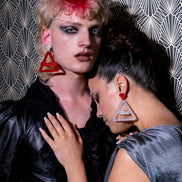 Two People Wearing Handmade Maine And Mara NAUGHTY And NICE Christmas Earrings in Silver And Red