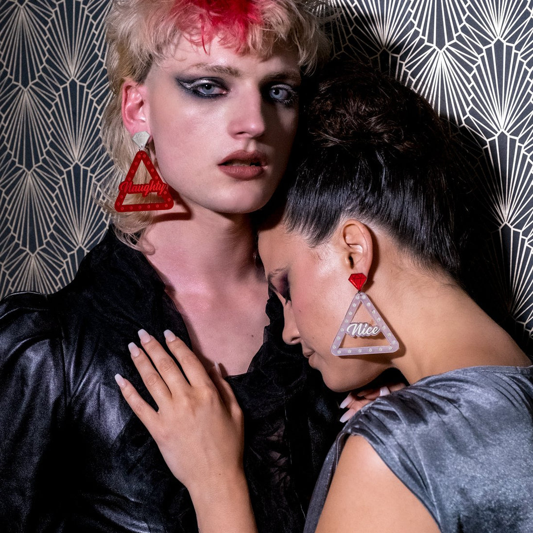 Two People Wearing Handmade Maine And Mara NAUGHTY And NICE Christmas Earrings in Silver And Red